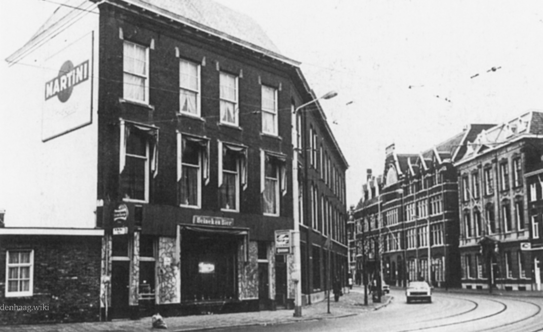 De Fluwelen Burgwal  gezien vanaf de hoek van de Wijnhaven. Rechts het hoofdgebouw van de Vrijmetselarij en de Landsdrukkerij. De foto werd in 1975 gemaakt.