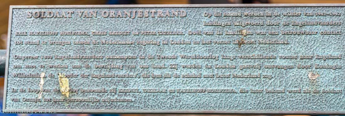 De tekst van de plaquette van het Soldaat van Oranjestrand is slecht leesbaar.