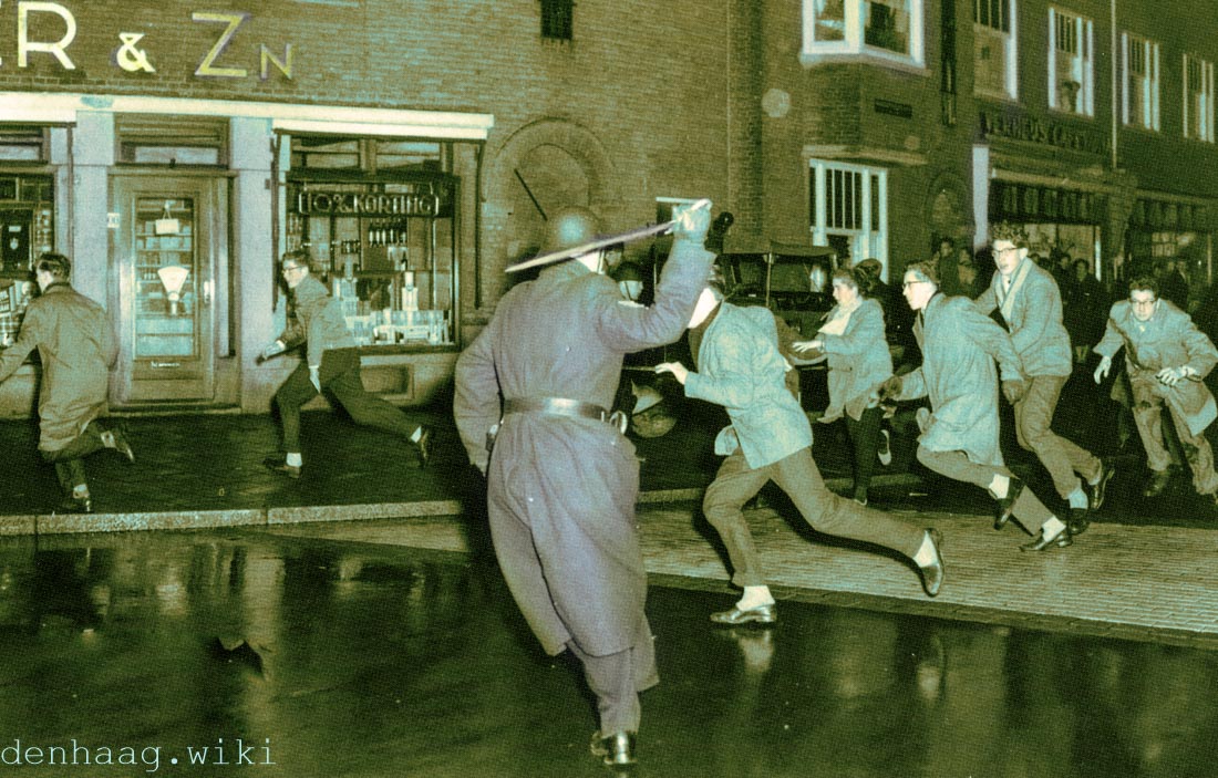 De kruising van de Goeverneurlaan en de Van Zeggelenlaan tijdens de jaarwisseling van 1957.  De politieagent gebruikt zijn sabel om de keurige nozems weg te jagen